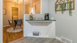 A kitchen with a coffee maker, a mirror, and a window with greenery. - The Robberson House close to Mercy, WOW, MSU (Springfield)