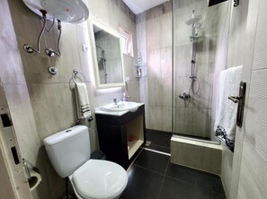 A modern bathroom with a toilet, sink, and shower. - Apartmani Katanera (Kraljevo)