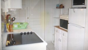 A kitchen with a stove, microwave, and cabinets.