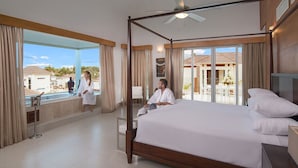 A spacious hotel room with a large bed, a balcony with a view of the surrounding area, and a ceiling fan. - Luxury Villas - Mandatory All-Inclusive (Puerto Plata)