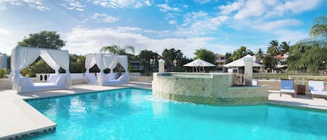 Una piscina al aire libre, camas de piscina gratis, sombrillas