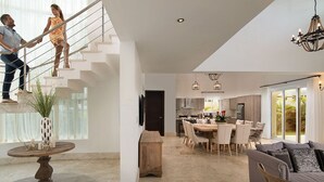 A modern living space with a staircase, dining area, and kitchen. - Luxury Villas - Mandatory All-Inclusive (Puerto Plata)