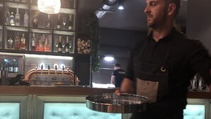 Un espace bar doté d’un comptoir capitonné, d’une tireuse à bière et d’une variété de bouteilles disposées en arrière-plan.
