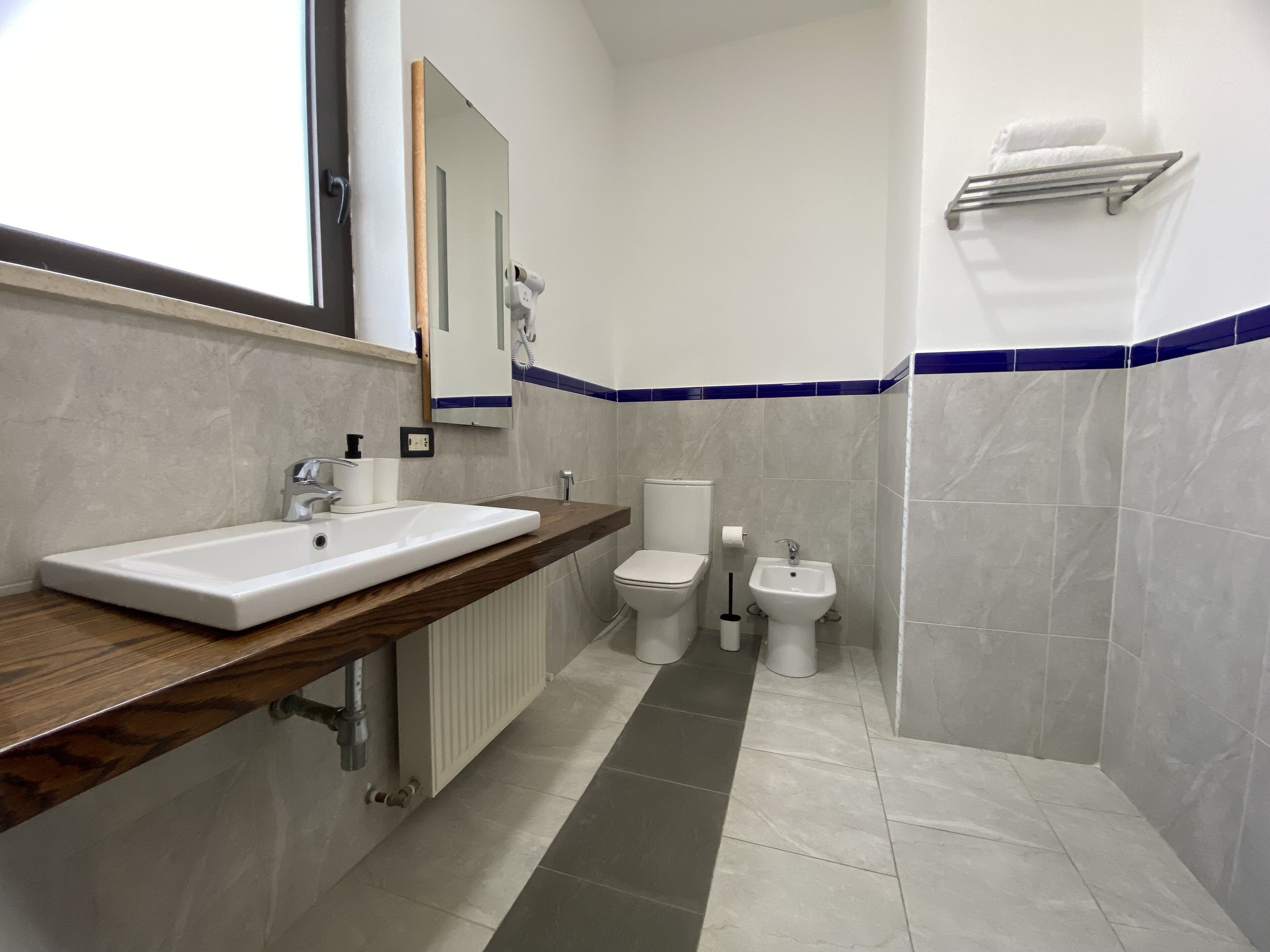 Ein modernes Badezimmer mit einem weißen Waschbecken, einer Toilette und einem Bidet.