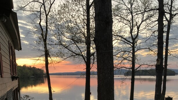A patio with outdoor furniture, a view of a lake, and trees. - Lake house with million dollar view & hot tub (Perryville)