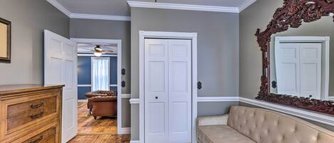 A hallway with a wooden dresser, a beige sofa, and a patterned rug.