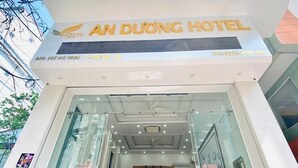 Das Außere Erscheinungsbild des An Duong Hotels mit moderner Fassade, großem Glas Eingang und sichtbarer Innenbereich-Sitzgelegenheit.
