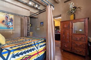 A room with a bed, a wooden cabinet, and a painting on the wall. - Turquoise Butterfly by Kokopelli Property Management (Santa Fe)