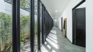 A modern hallway with large windows, a tiled floor, and a door on the right. - 350m to Beach - Guitar-shaped Pool Kitchen - BBQ Casa Guitarra (Tempate)