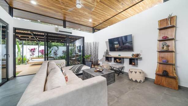 A modern living room with a wooden ceiling, a large TV mounted on the wall, and a built-in shelf with decorative items. - 350m to Beach - Guitar-shaped Pool Kitchen - BBQ Casa Guitarra (Tempate)