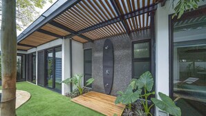A modern building with a wooden deck, artificial grass, and large plants. - 350m to Beach - Guitar-shaped Pool Kitchen - BBQ Casa Guitarra (Tempate)