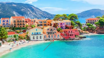 Une ville côtière aux bâtiments aux couleurs vives, avec une plage et une mer d’un bleu limpide.