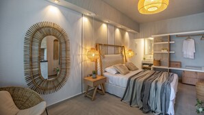 Ein modernes Schlafzimmer mit einem großen Bett, Nachttischlampen, einem Spiegel und einem Kleiderschrank.