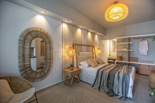 A modern bedroom with a large bed, bedside lamps, a mirror, and a wardrobe.