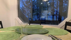 A dining table set with green placemats, a white plate, a glass, and cutlery. - Lake house, amazing view, hot tub (Perryville)