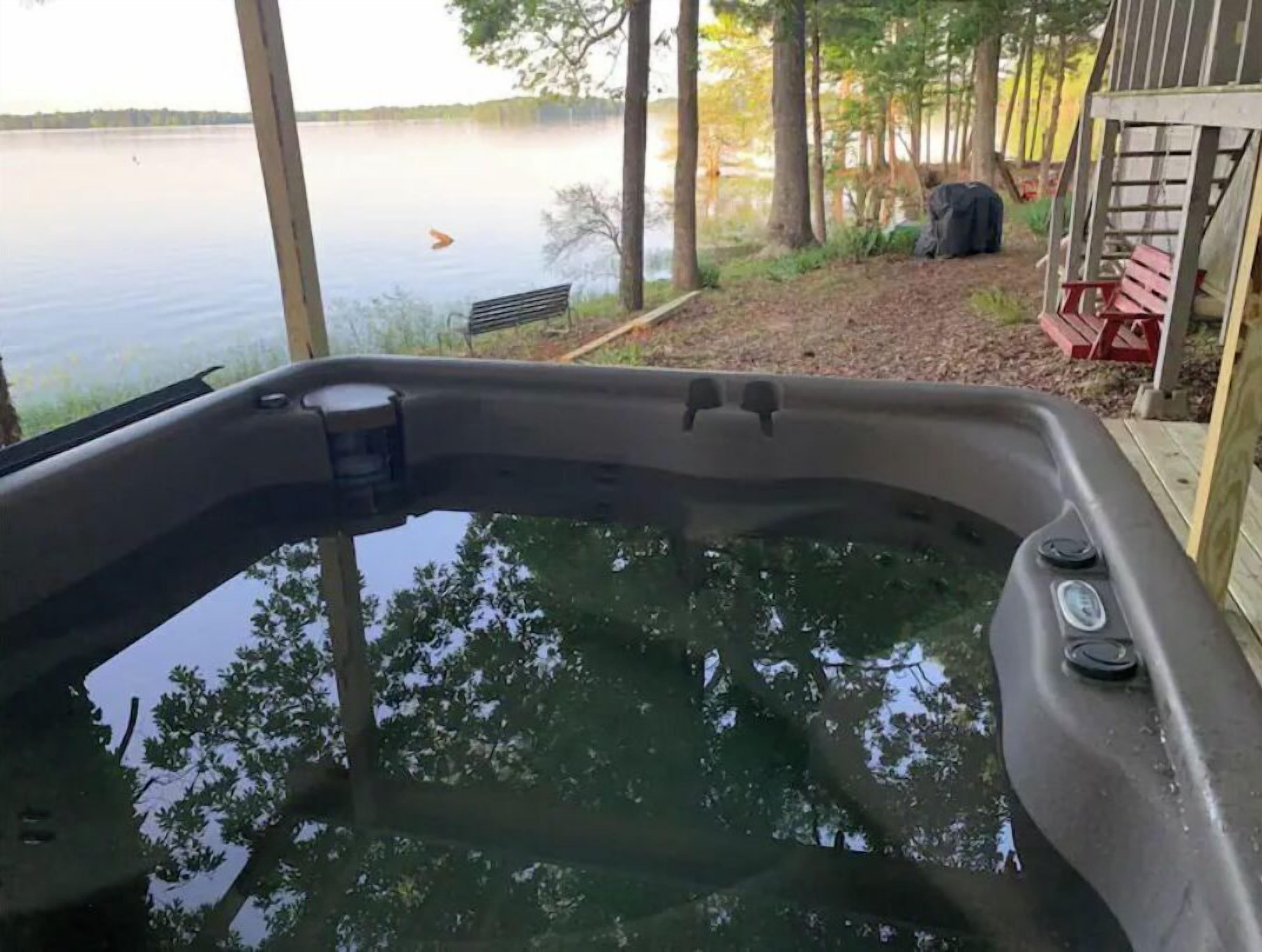 Ein Whirlpool mit Blick auf einen See und Bäume.