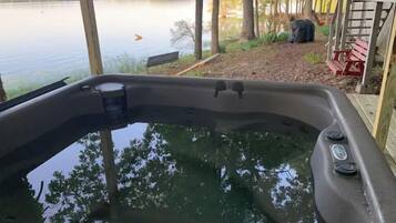 Ein Whirlpool mit Blick auf einen See und Bäume.