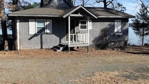 A small, single-story house with a front porch and a chimney. - Lake house, amazing view, hot tub (Perryville)