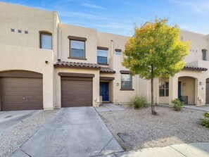 A two-story residential building with a driveway, garage doors, and a small tree in the front yard. - Large 3br 2-story townhouse with pool 2 mi to ASU (Tempe)