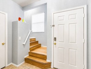 A staircase leading to a landing with a white door and a window with blinds. - Pet-Friendly 3BR | Community Pool | Near ASU (Tempe)