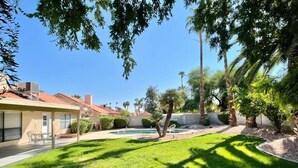 A residential property with a well-maintained lawn, a swimming pool, and a patio area. - Pristine! Single-Story Home with Pool in Chandler (Chandler)