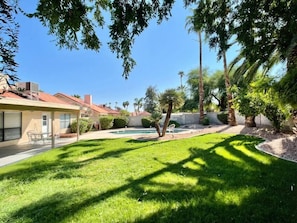 A residential property with a well-maintained lawn, a swimming pool, and a patio area. - Pristine! Single-Story Home with Pool in Chandler (Chandler)