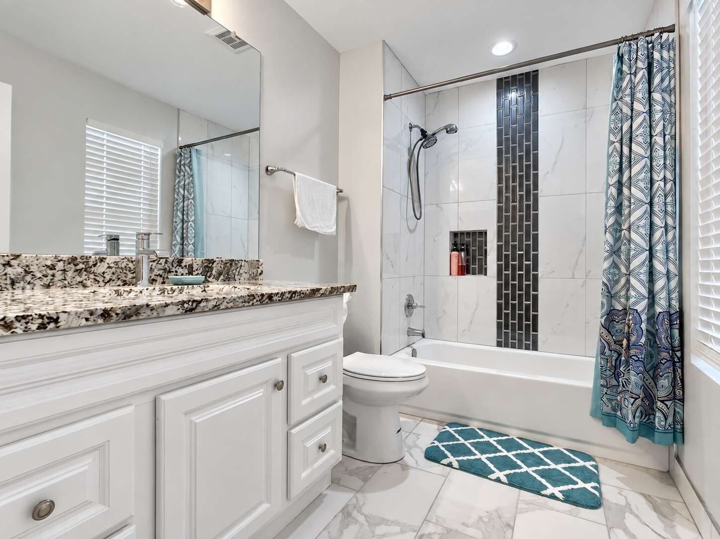 A modern bathroom with a shower, toilet, and vanity.