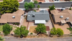 Un quartier résidentiel composé de plusieurs maisons, chacune ayant un style de toit distinct, et certaines étant équipées d’antennes paraboliques.