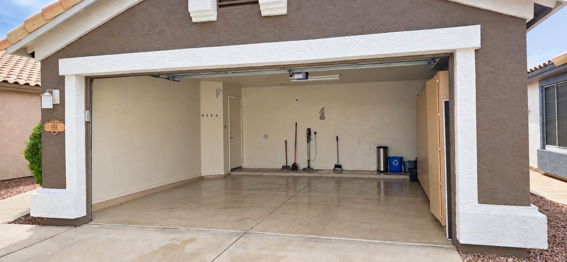 A garage with a clean, tiled floor and a closed door.