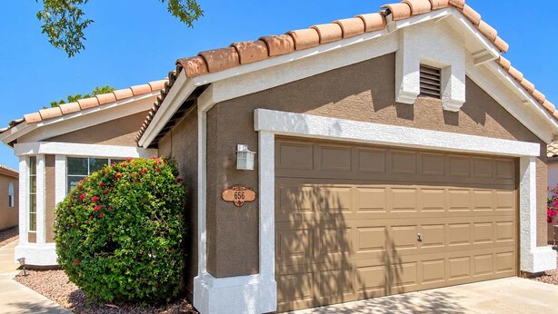 A residential house with a garage, a mailbox, and a well-maintained lawn.