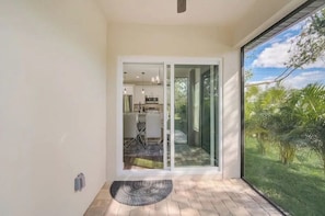 A modern interior with a sliding glass door leading to a kitchen and dining area.