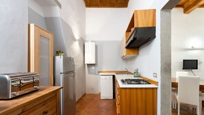 Una cocina compacta con tostadora, refrigerador, lavavajillas y estufa.