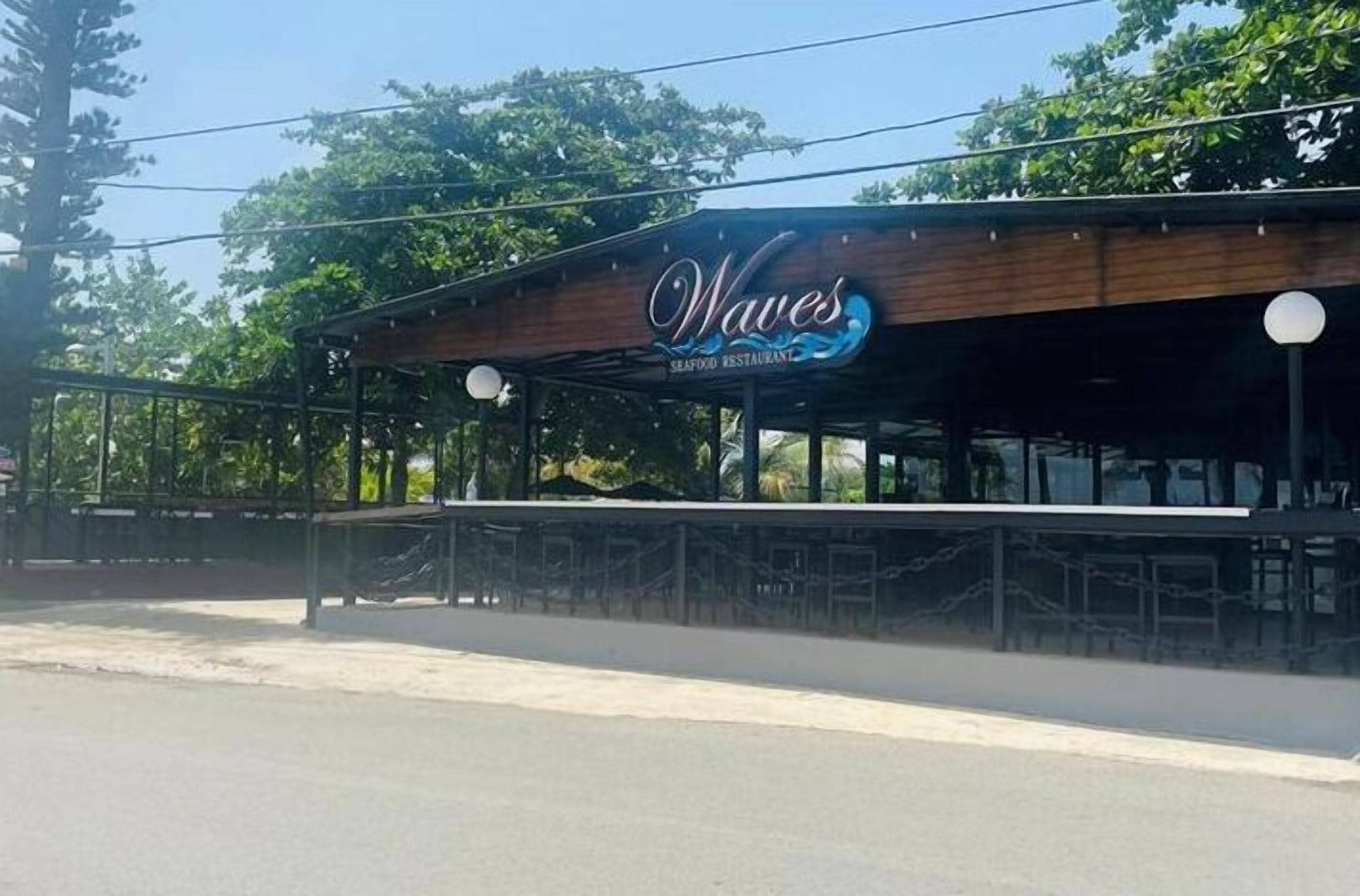 A seafood restaurant named 'Waves' with a covered outdoor seating area and a wooden facade.