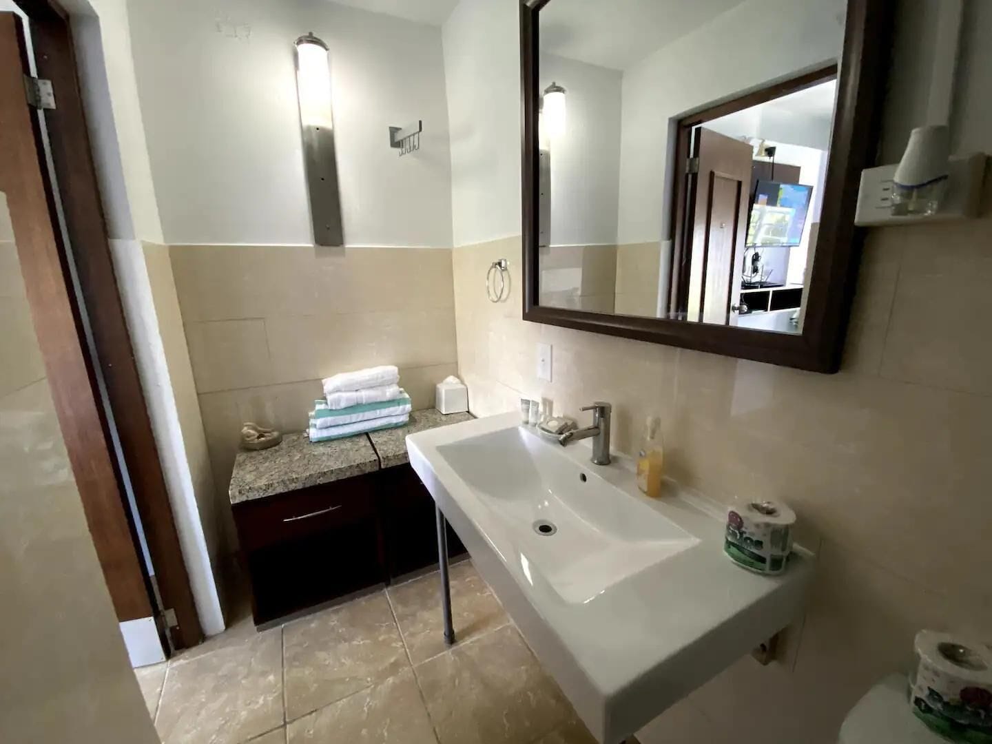 A bathroom with a white sink, a mirror, and a towel rack.