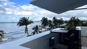 A balcony with a view of the ocean and palm trees. - Mares Guesthouse (Aguada)