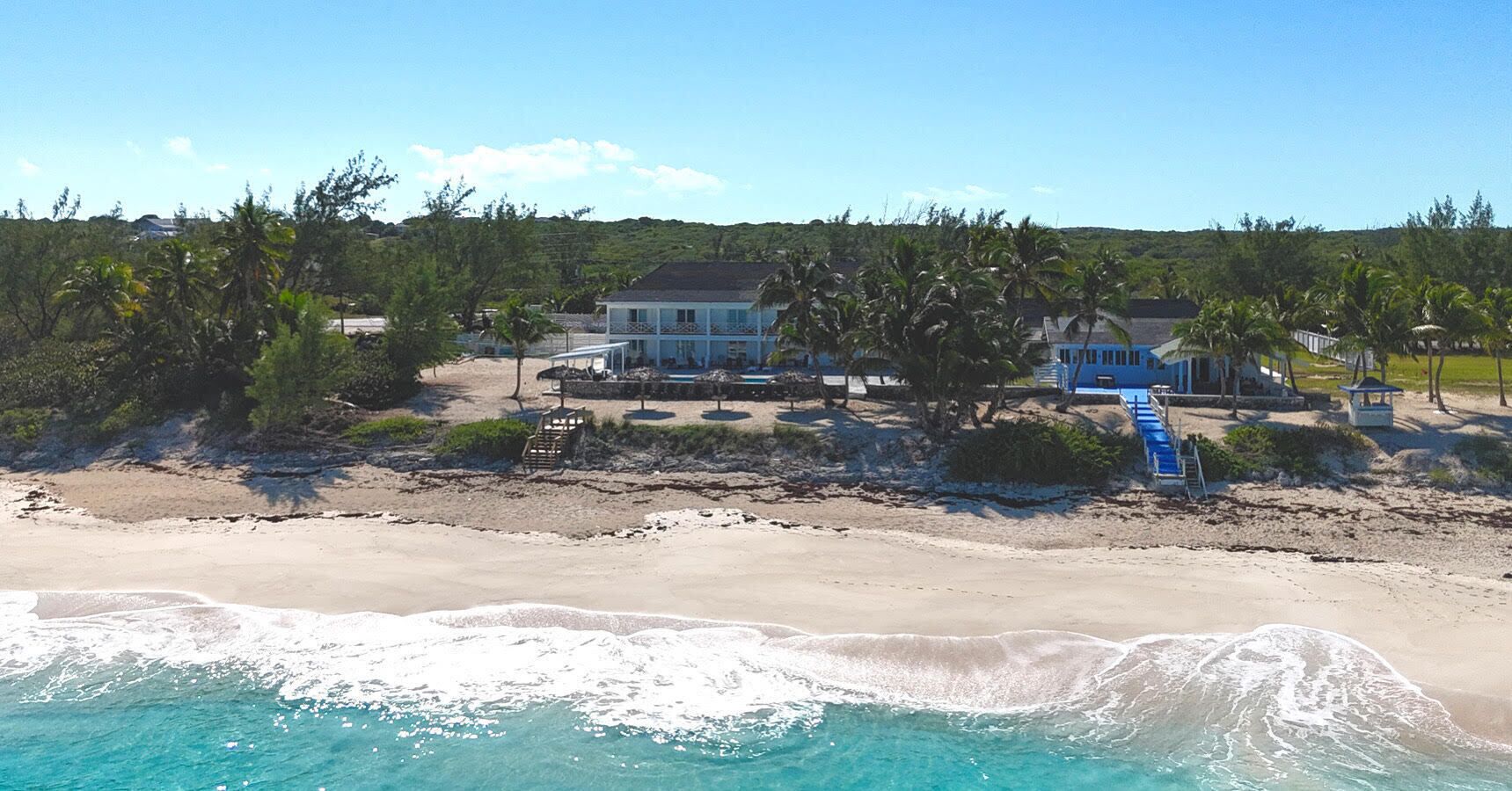 Une propriété située en bord de mer, dotée d’une piscine, d’une plage et offrant une vue sur l’océan.