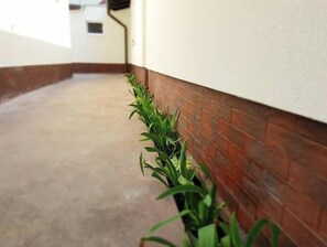 Un couloir doté d’un sol en béton et d’un mur en briques sur un de ses côtés.