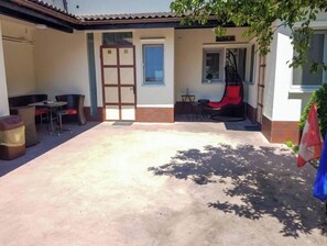 Un patio couvert comprenant un espace aménagé avec des sièges, une porte et une fenêtre.