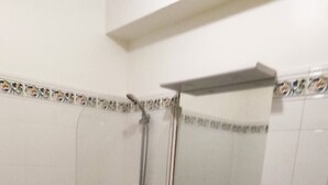Un baño con bañera, lavabo con espejo e inodoro.
