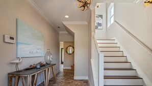 A staircase with white railings and wooden steps leading to a second floor.