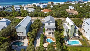 A residential area with houses, a swimming pool, and a view of the ocean.