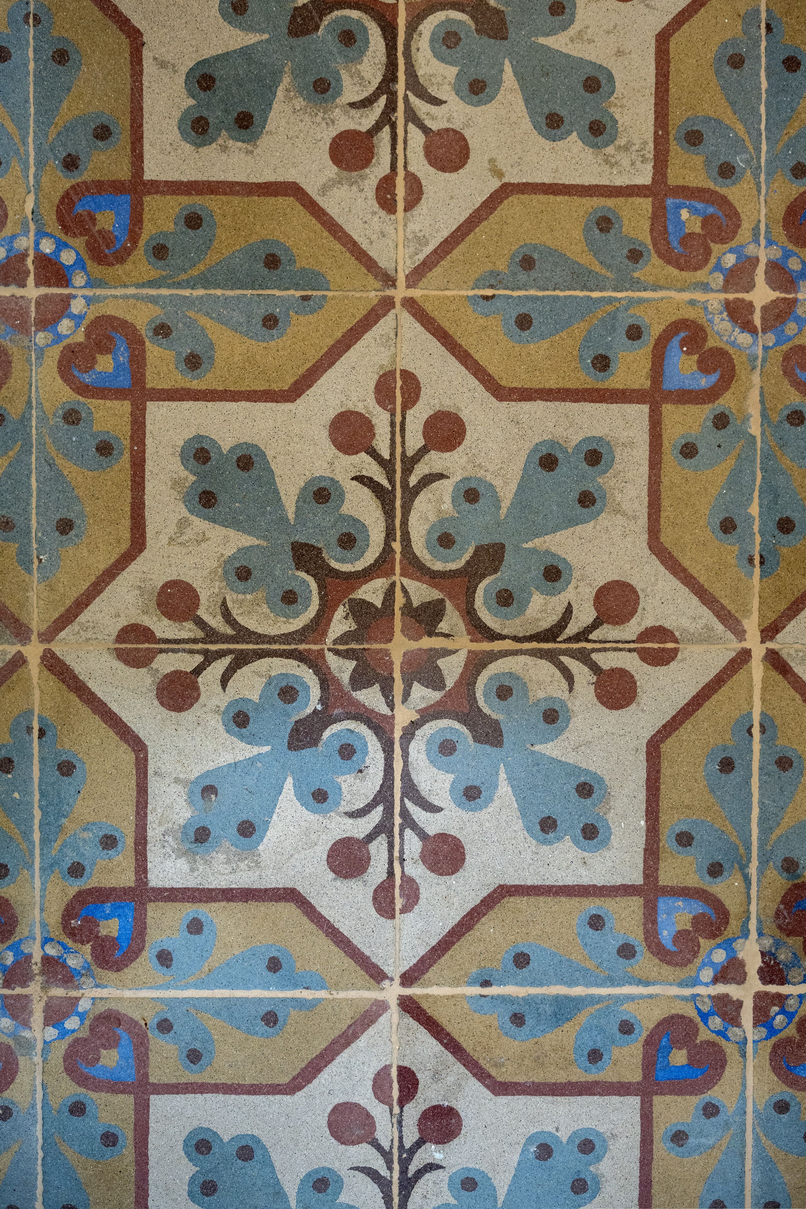 Un sol carrelé orné de motifs géométriques et floraux.