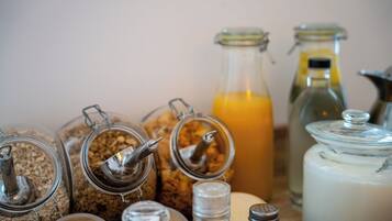 Diversos recipientes de vidrio con tapas, incluyendo frascos y botellas, presumiblemente conteniendo alimentos o condimentos.