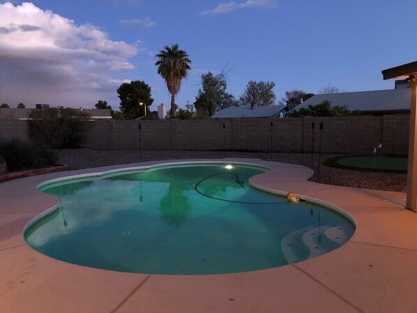 A swimming pool with a curved edge, surrounded by a concrete deck and a low brick wall. - Very own Arizona retreat with private pool and putting green. Sleeps six (Chandler)