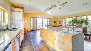 A spacious kitchen with a large island, wooden cabinets, and a modern faucet. - Mtn-View Home w/ Fenced Backyard in Rimrock! (Rimrock)