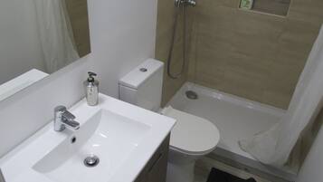 Executive suite | Badkamer | Een douche, een regendouche, een haardroger, handdoeken
