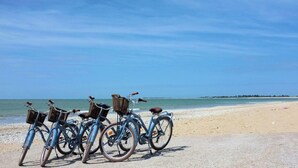 A row of bicycles parked on a sandy beach with the ocean in the background. - 200m from the ocean, villa "Lupin" in residence with swimming pool . : Les Thalassiles (Fouras)