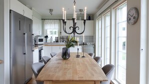 Eine moderne Küche mit einem Holztisch, Edelstahlgeräten und einem Kronleuchter.