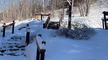 A snow-covered outdoor area with wooden steps leading up to a building.