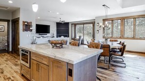 Una cocina espaciosa con una isla grande, armarios de madera y un televisor integrado.